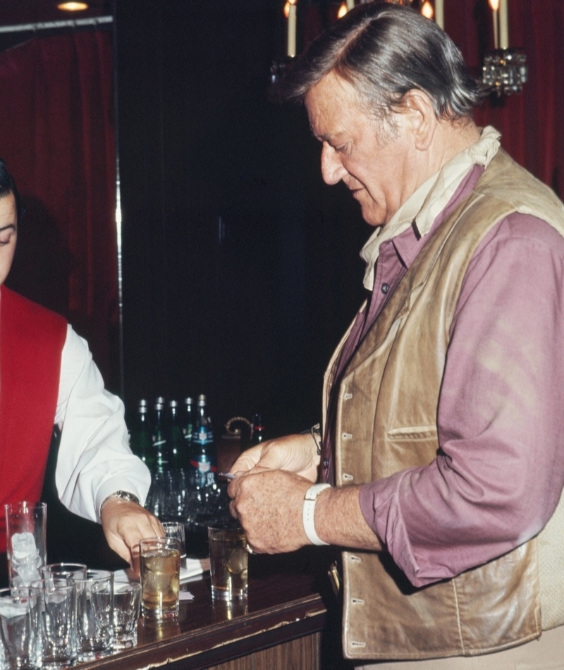John Wayne bebe un trago en una fiesta de disfraces | Getty Images Photo by Michael Ochs Archives